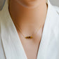 Tiger Eye gemstone necklace. A smooth polished Tiger Eye stone in a bar or tube shape set onto a 14k gold filled chain. Modeled image.