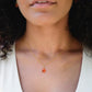 Natural orange triangular shaped Carnelian gemstone set onto a gold chain. Modeled image. 