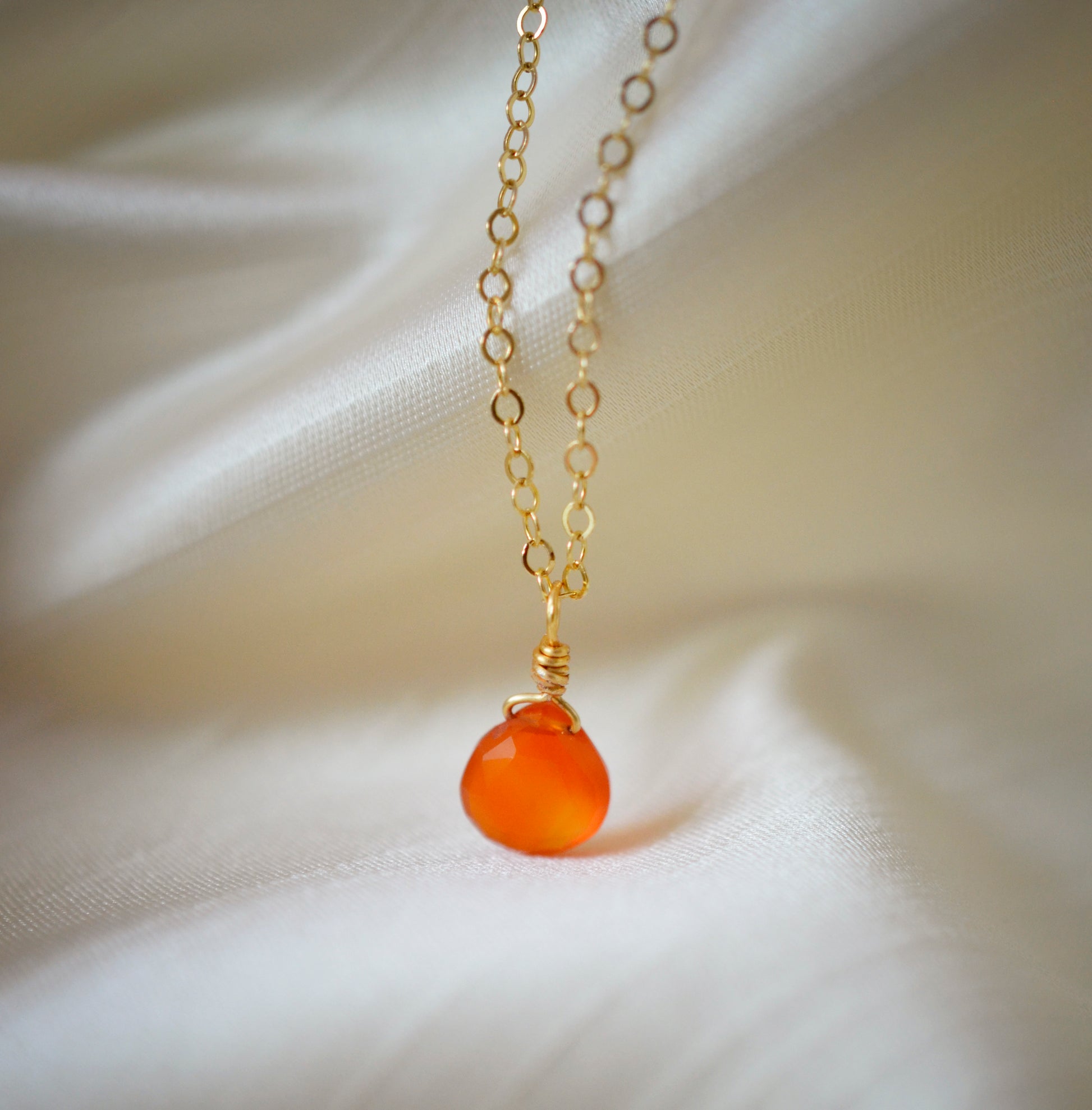 Natural orange Carnelian teardrop gemstone set onto a 14k gold filled chain.