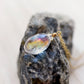 Close up image of the rainbow colors within the Mystic Topaz. The gemstone is a faceted teardrop shape. The 14k gold filled style is shown.