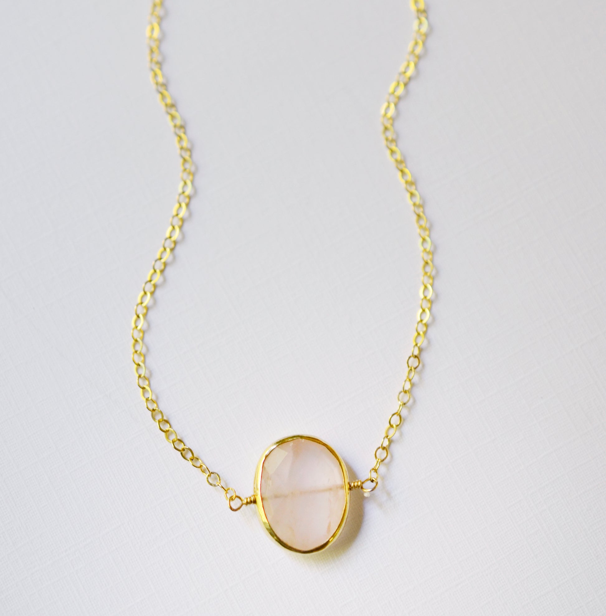 Dainty pink Rose Quartz oval coin shaped pendant with gold bezel. Chain is 14k Gold Filled.