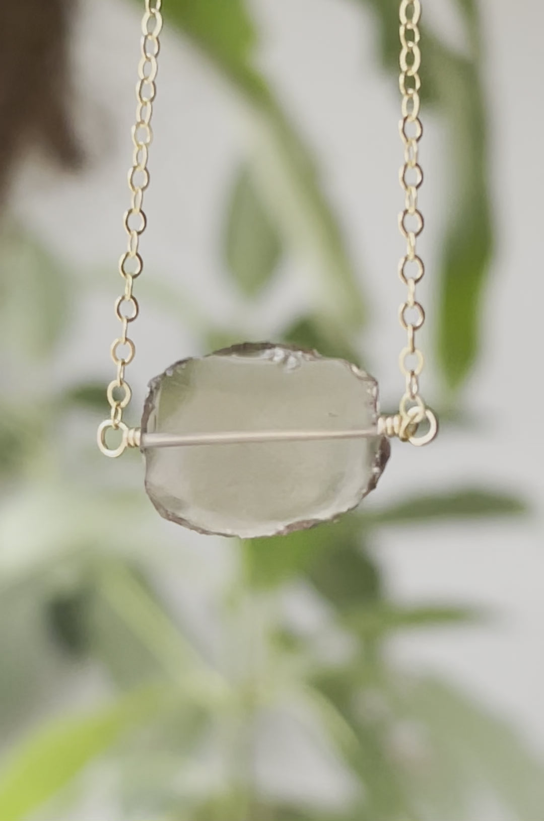 An irregular oval shape, smooth polished Smokey Quartz stone set onto a 14k gold filled chain. The stones edges are raw and irregular. Video.