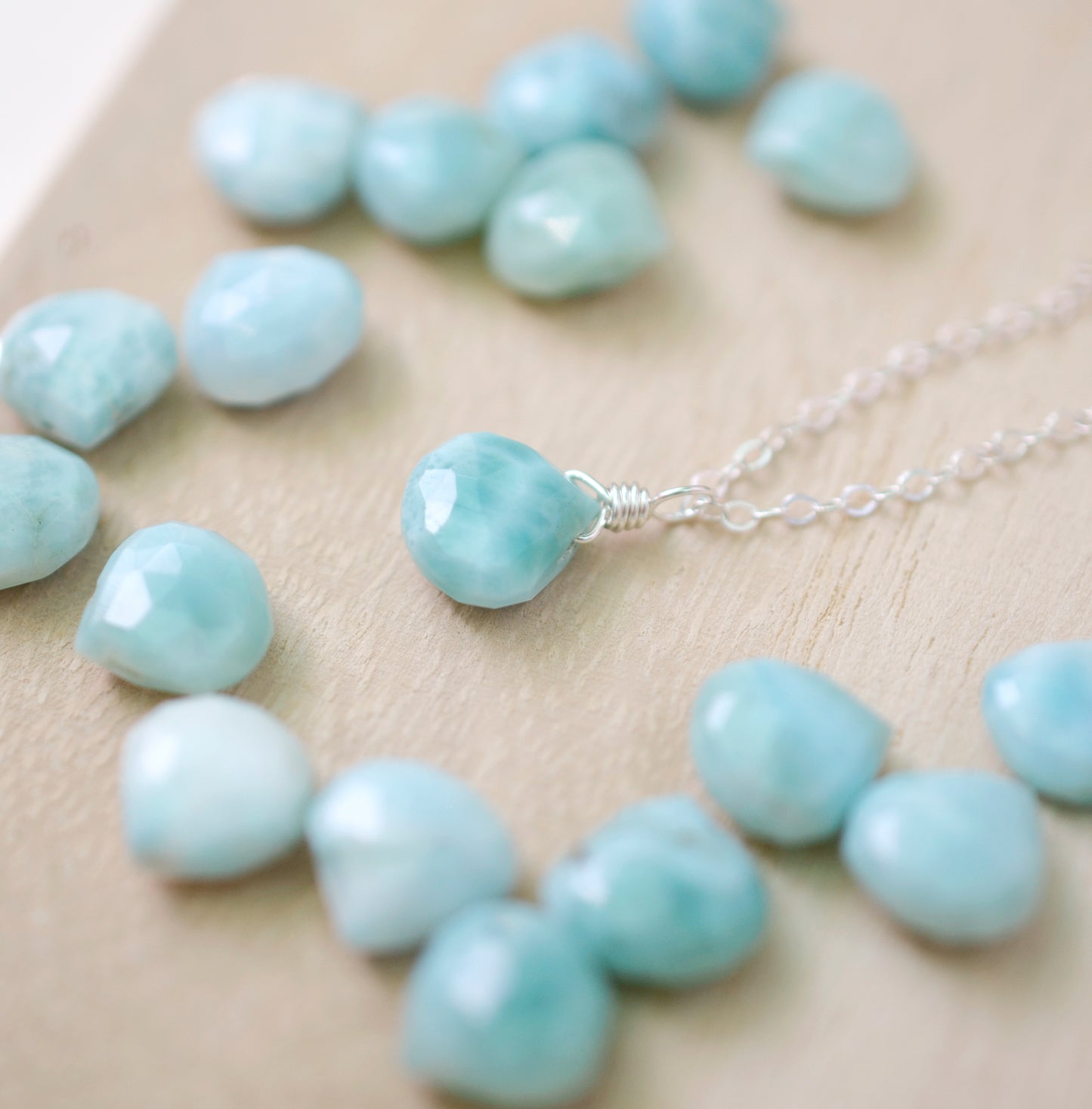 Close up of blue Larimar stone options with a sterling silver necklace sample.